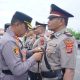 Kapolres Lhokseumawe AKBP Dr. Ahzan, S.H., S.I.K., M.S.M., M.H. memasangkan tanda jabatan kepada pejabat baru dalam upacara serah terima jabatan (sertijab) di Lapangan Satya Haprabu Polres Lhokseumawe, Senin (28/4/2025).