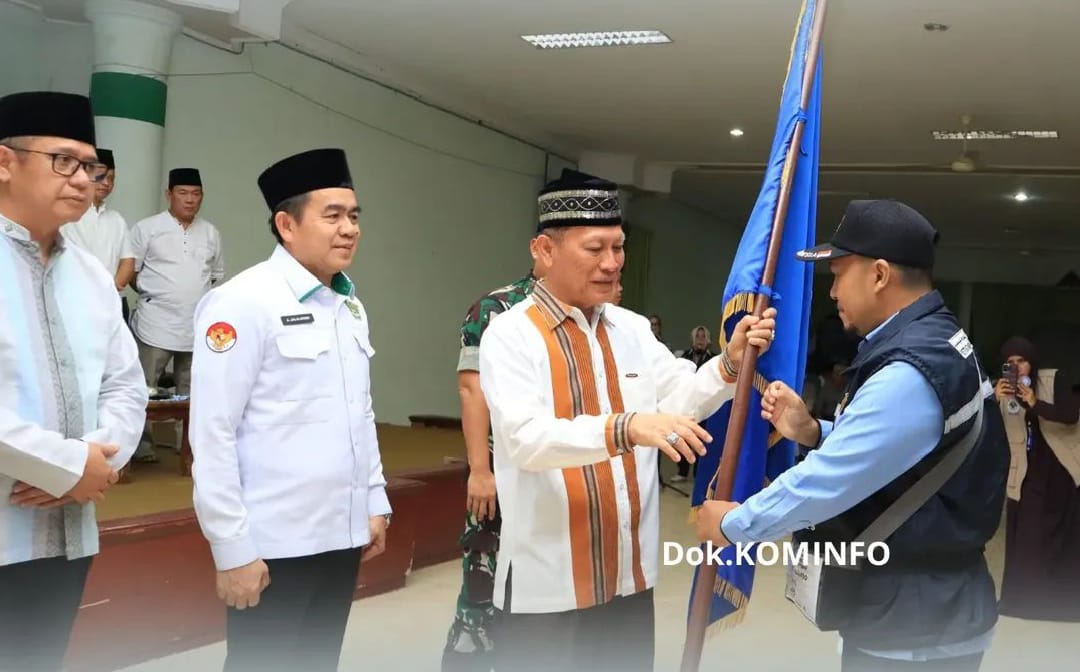Bupati Tulang Bawang, Drs. Qudrotul Ikhwan, M.M., secara simbolis menyerahkan bendera regu kepada perwakilan petugas pendamping jemaah haji dalam acara pelepasan 202 calon jemaah haji tahun 2025 di Aula Islamic Center Menggala, Senin (19/5/2025). Seremoni ini menandai kesiapan keberangkatan jemaah ke Tanah Suci.