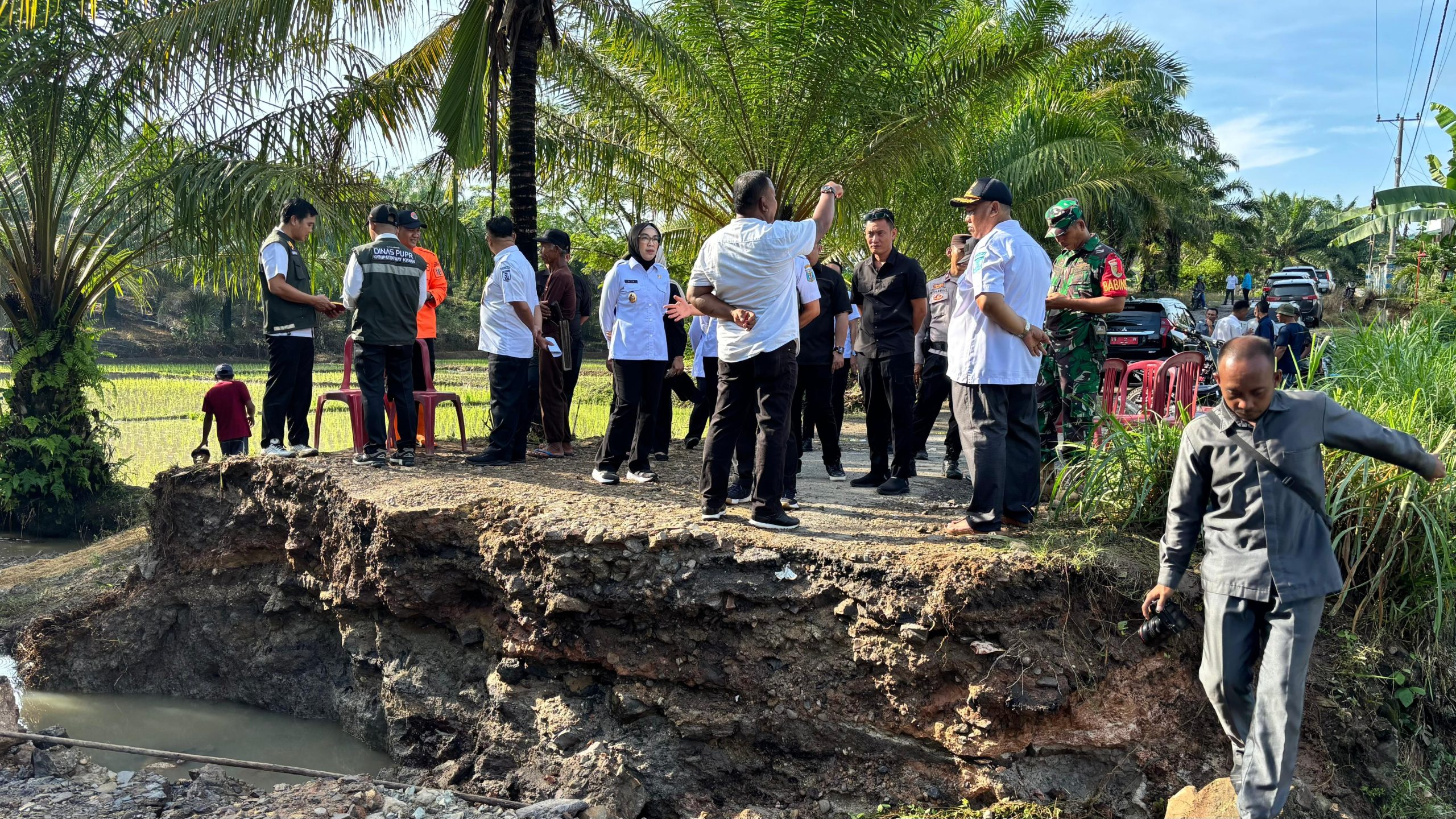 Plt Bupati Way Kanan Ayu Asalasiyah bersama jajaran didampingi Camat Bumi Agung dan Anggota DPRD Bahari Sanjaya meninjau lokasi gorong-gorong ambruk di Jalan Lintas Kabupaten, Kampung Tanjung Dalam, Rabu (14/5/2025). Pemerintah setempat dan warga telah membangun jembatan darurat untuk memulihkan akses sementara.