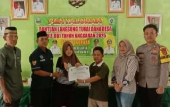 Peratin Pekon Pemerihan, Dahril (tiga dari kiri), secara simbolis menyerahkan Bantuan Langsung Tunai Dana Desa (BLT-DD) Tahap I dan II Tahun 2025 kepada salah satu Keluarga Penerima Manfaat (KPM), didampingi oleh jajaran aparatur pekon dan unsur Forkopimcam Krui Selatan, Jumat (13/06/2025).