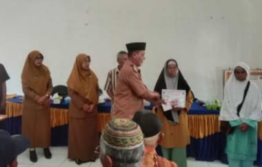 Peratin Way Sindi Asahan, Ismadi, secara simbolis menyerahkan Bantuan Langsung Tunai Dana Desa (BLT-DD) Tahap I dan II Tahun 2025 kepada salah satu Keluarga Penerima Manfaat (KPM) di Balai Pekon setempat, Senin (16/6/2025).