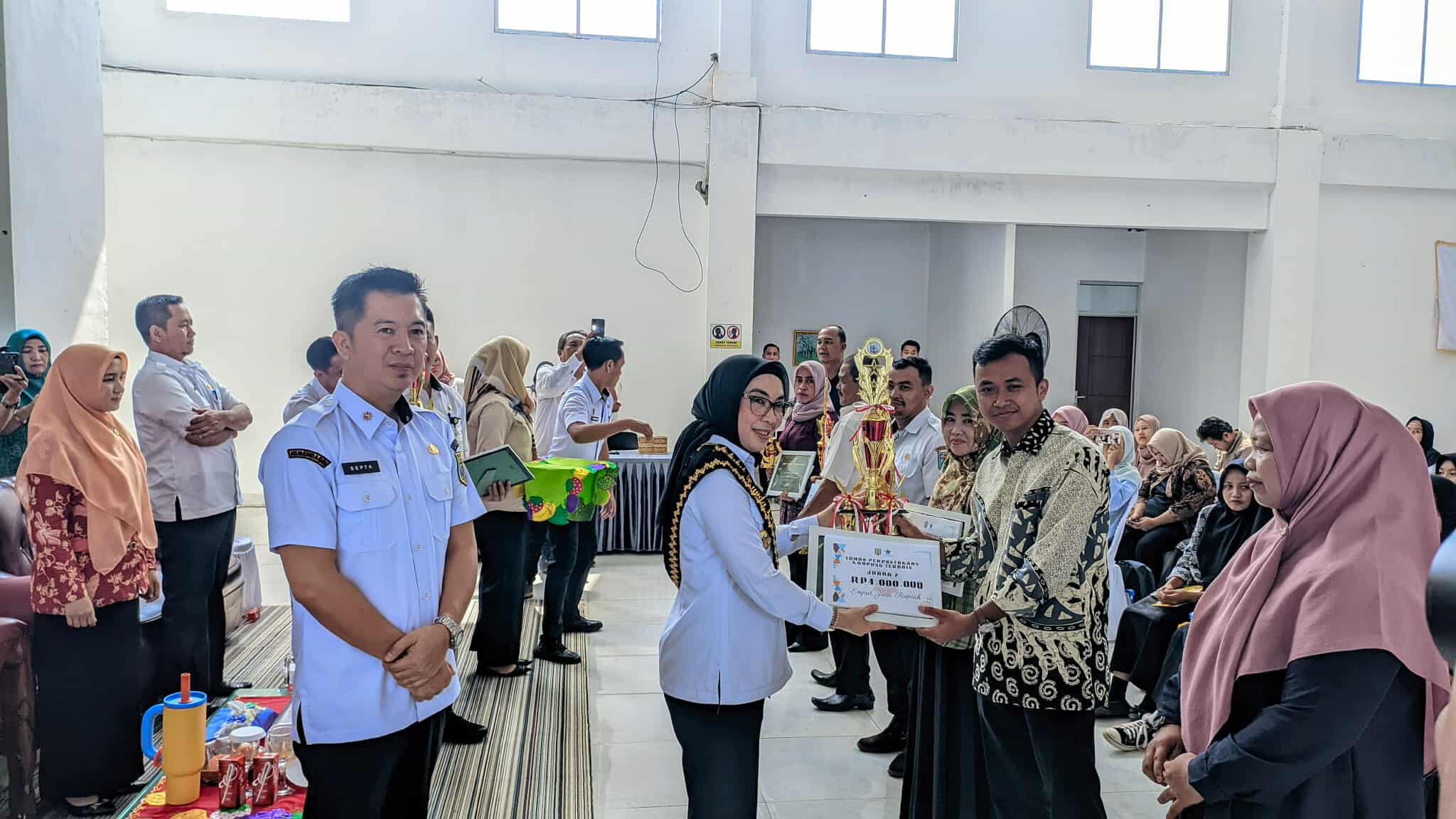 Bupati Way Kanan, Ayu Asalasiyah, S.Ked., menyerahkan secara simbolis penghargaan dan bantuan senilai Rp14.000.000 kepada perwakilan Perpustakaan Kampung Terbaik dalam acara Lokakarya Literasi Digital di Aula Dinas Perpustakaan dan Arsip, Rabu (30/7/2025).