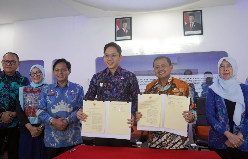 Bupati Lampung Selatan Radityo Egi Pratama dan Bupati Sumedang Dony Ahmad Munir menunjukkan dokumen Nota Kesepahaman (MoU) dan Perjanjian Kerja Sama (PKS) usai penandatanganan kerja sama antardaerah dalam bidang berbagi informasi dan inovasi pemerintahan, Jumat (4/7/2025)