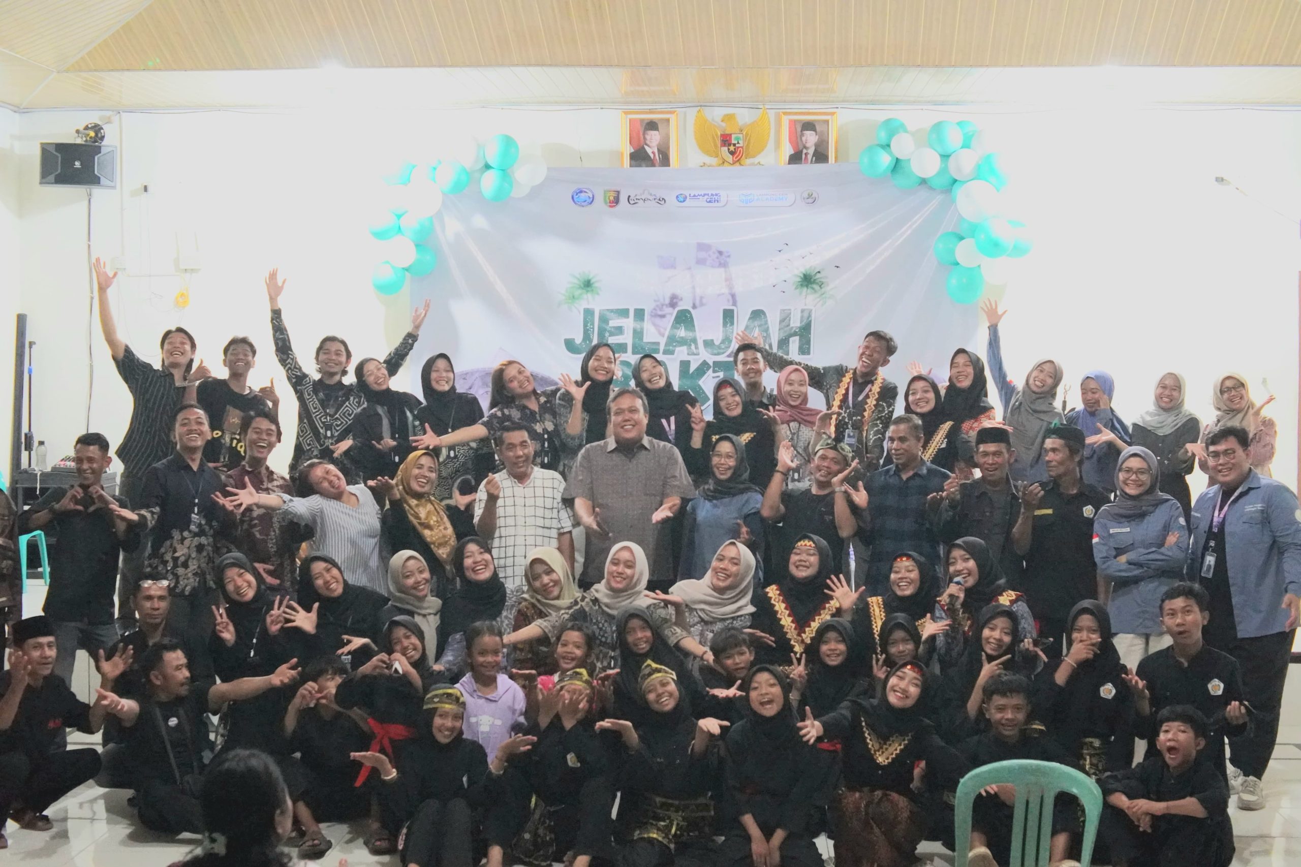 Para relawan Jelajah Bakti 2025 berfoto bersama masyarakat Desa Cilimus dalam malam puncak keakraban yang penuh semangat dan keceriaan, menandai berakhirnya rangkaian kegiatan sosial, edukasi, dan budaya yang berlangsung selama lima hari di Kecamatan Teluk Pandan, Kabupaten Pesawaran