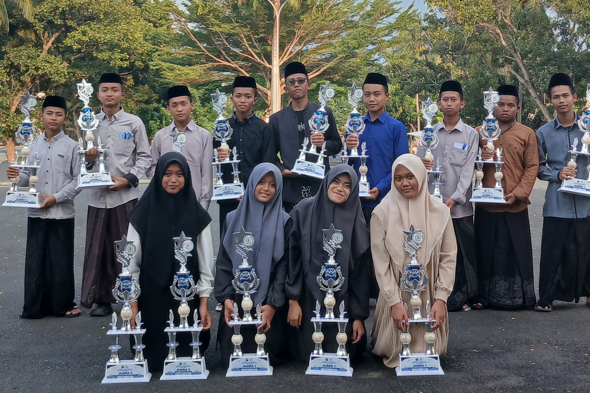 Para santri PPTQ Assahil berpose dengan deretan piala kemenangan usai meraih juara di berbagai cabang lomba dalam ajang Seleksi Tilawatil Qur’an (STQ) Kabupaten Lampung Selatan 2025 yang digelar di Kalianda, 22–24 Juli 2025.