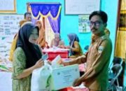 Peratin Batu Raja, Edwarlin, secara simbolis menyerahkan bantuan beras kepada salah satu warga penerima manfaat dalam kegiatan penyaluran bantuan pangan Cadangan Beras Pemerintah (CBP) di Balai Pekon Batu Raja, Kecamatan Pesisir Utara, Selasa (29/7/2025).