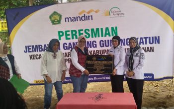 Bupati Way Kanan Ayu Asalasiyah, S.Ked., bersama Ketua PIISEI Anggito Abimanyu dan perwakilan Bank Mandiri memegang prasasti peresmian Jembatan Gantung Gunung Katun di Kecamatan Baradatu, Rabu (13/8/2025).