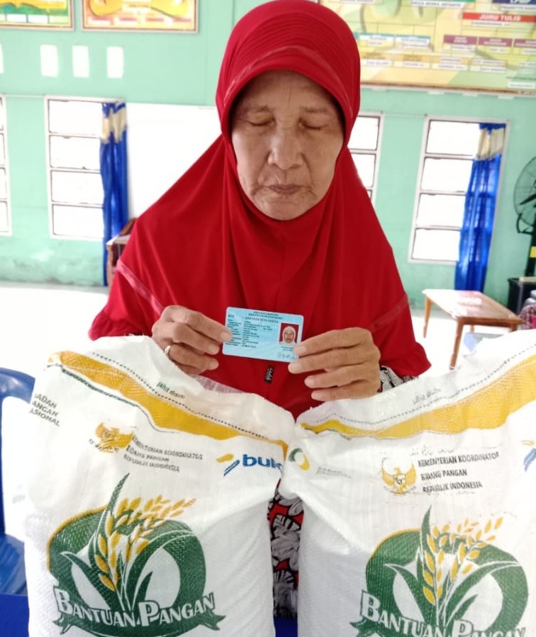 Warga penerima manfaat menunjukkan identitas diri saat menerima bantuan beras dari Cadangan Beras Pemerintah (CBP) di Balai Pekon Pagar Dalam, Kecamatan Pesisir Selatan, Kabupaten Pesisir Barat, Kamis (1/8/2025).
