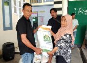 Peratin Pekon Biha, Rizkon Alhuda, S.H., menyerahkan bantuan beras kepada salah satu warga penerima manfaat di Balai Pekon Biha, Kecamatan Pesisir Selatan, Jumat (1/8/2025).