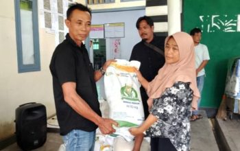 Peratin Pekon Biha, Rizkon Alhuda, S.H., menyerahkan bantuan beras kepada salah satu warga penerima manfaat di Balai Pekon Biha, Kecamatan Pesisir Selatan, Jumat (1/8/2025).