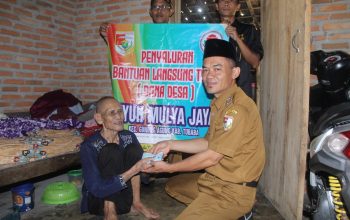 Kepala Tiyuh Mulya Jaya, Imam Mastur, menyerahkan langsung Bantuan Langsung Tunai Dana Desa (BLT-DD) kepada salah satu warga lansia penerima manfaat di Kecamatan Gunung Agung, Tubaba.