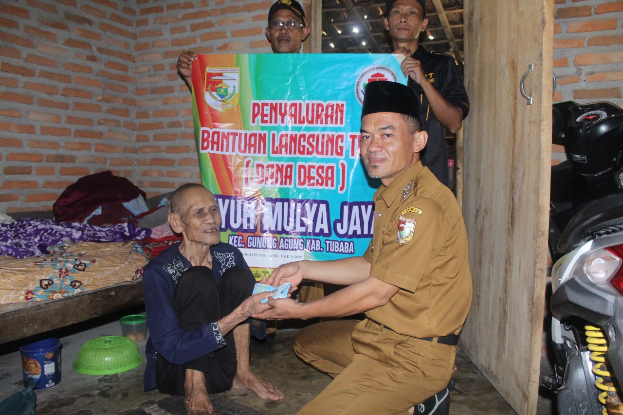 Kepala Tiyuh Mulya Jaya, Imam Mastur, menyerahkan langsung Bantuan Langsung Tunai Dana Desa (BLT-DD) kepada salah satu warga lansia penerima manfaat di Kecamatan Gunung Agung, Tubaba.