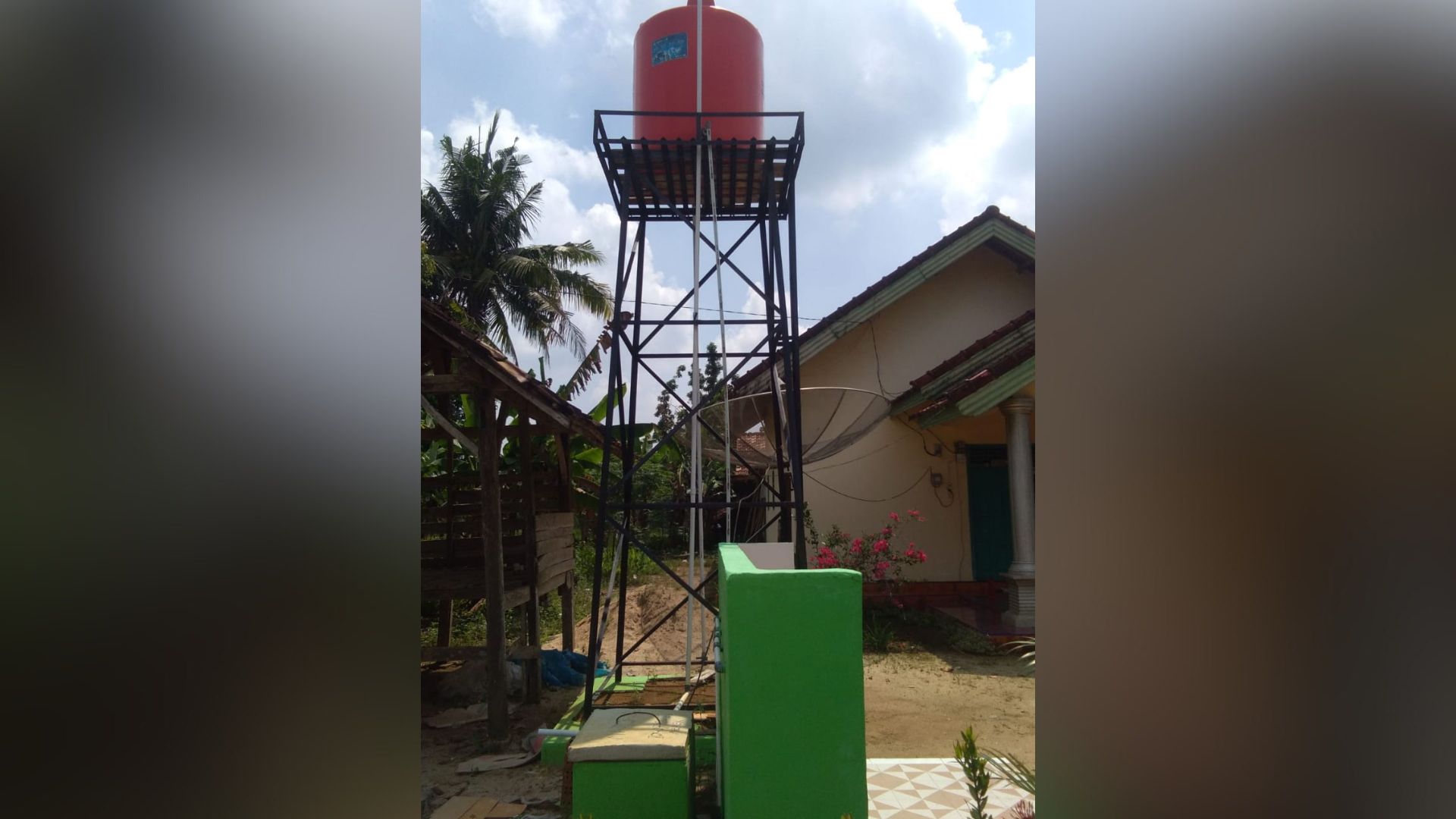 Sumur bor modern lengkap dengan tower dan tangki penampung air merah yang telah dibangun di lingkungan Suku 03, Tiyuh Dwikora Jaya.