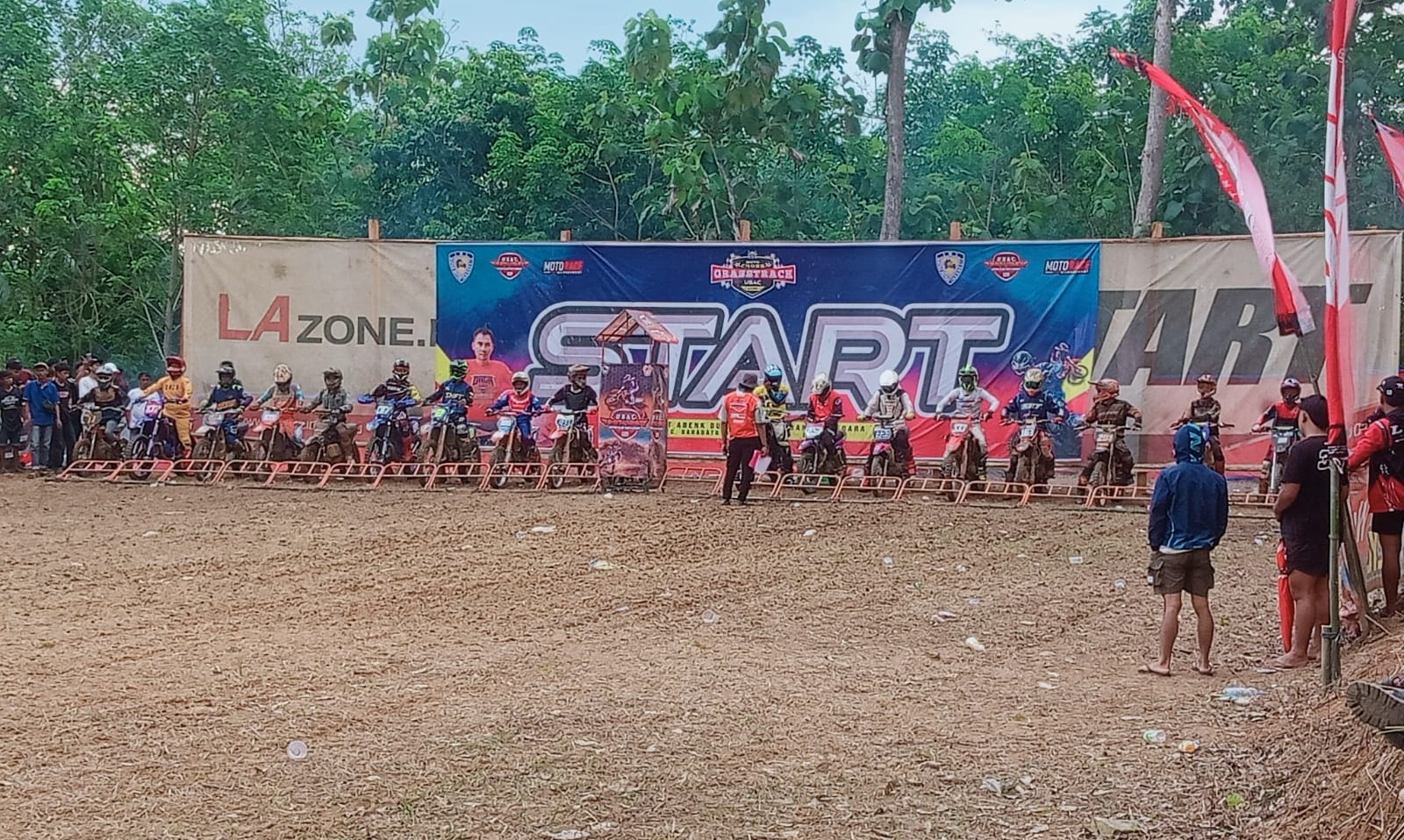 Deretan pembalap bersiap di garis start ajang Moto Cross Grasstrack USAC 2025 di Sirkuit Abenk Bukit Superli, Baradatu, Minggu (24/8/2025).