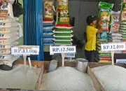 Seorang pedagang menata karung beras kemasan di kiosnya di Pasar Leuwiliang, Kabupaten Bogor, Selasa (5/8/2025).