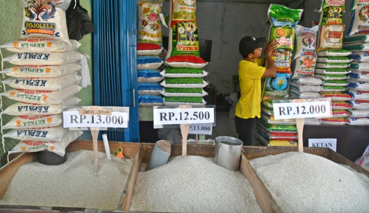 Seorang pedagang menata karung beras kemasan di kiosnya di Pasar Leuwiliang, Kabupaten Bogor, Selasa (5/8/2025).