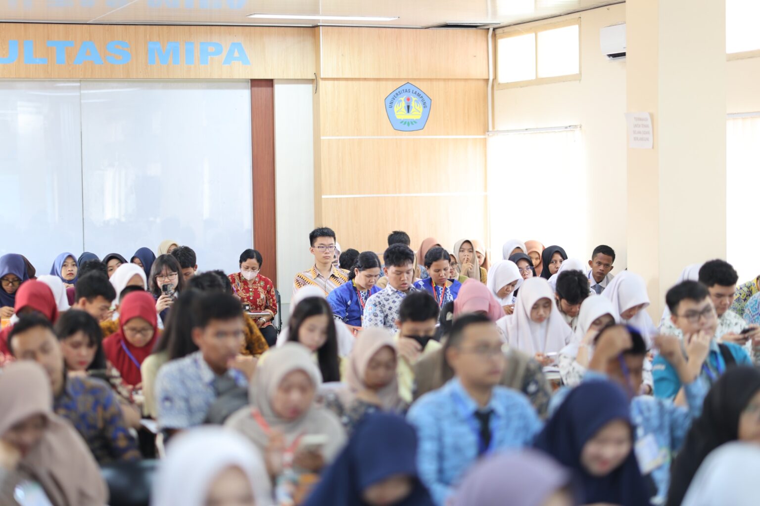 Peserta Osamakom 2025 memenuhi aula FMIPA Unila, siap berkompetisi dan berkolaborasi dalam bidang sains, matematika, dan komputer.